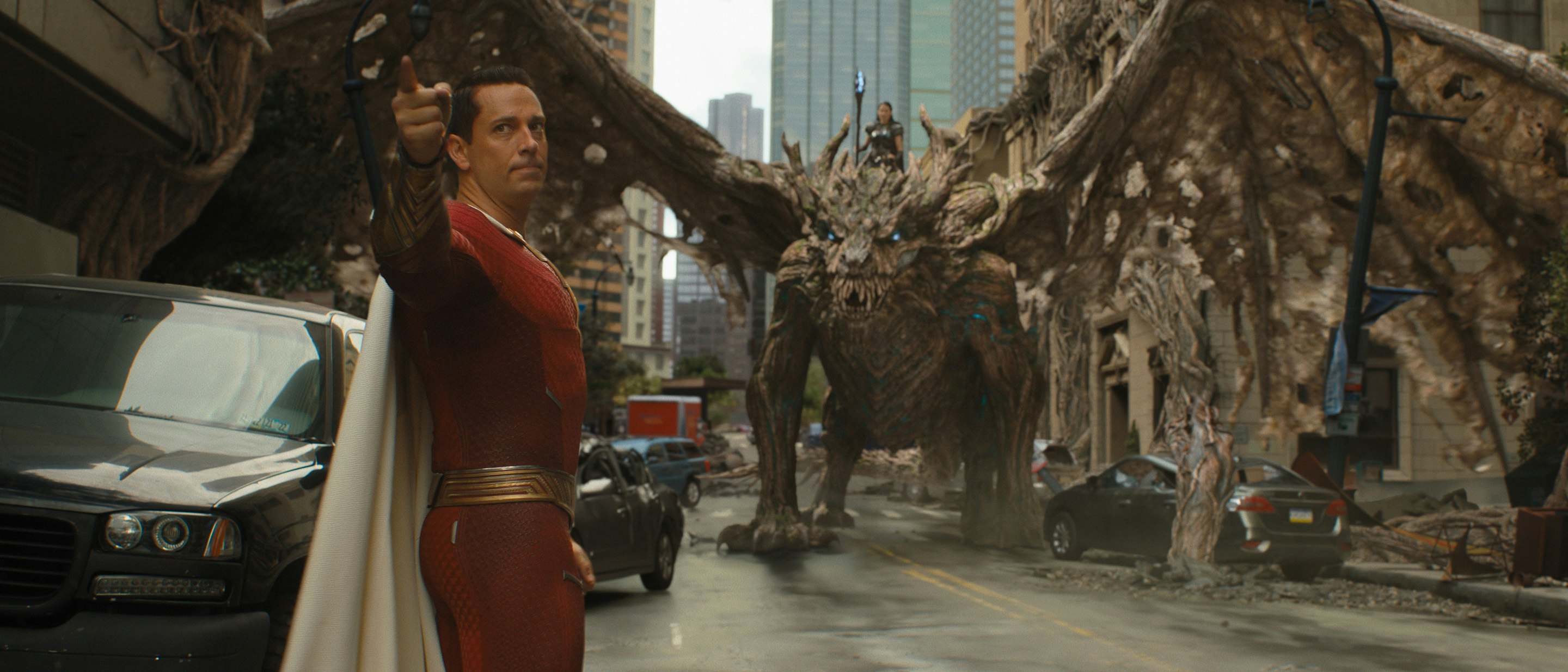 Shazam points finger mid-fight with dragon behind him. See Shazam with on-screen captions on Saturday March 18 and Wednesday March 22 at 4PM at select Harkins locations.